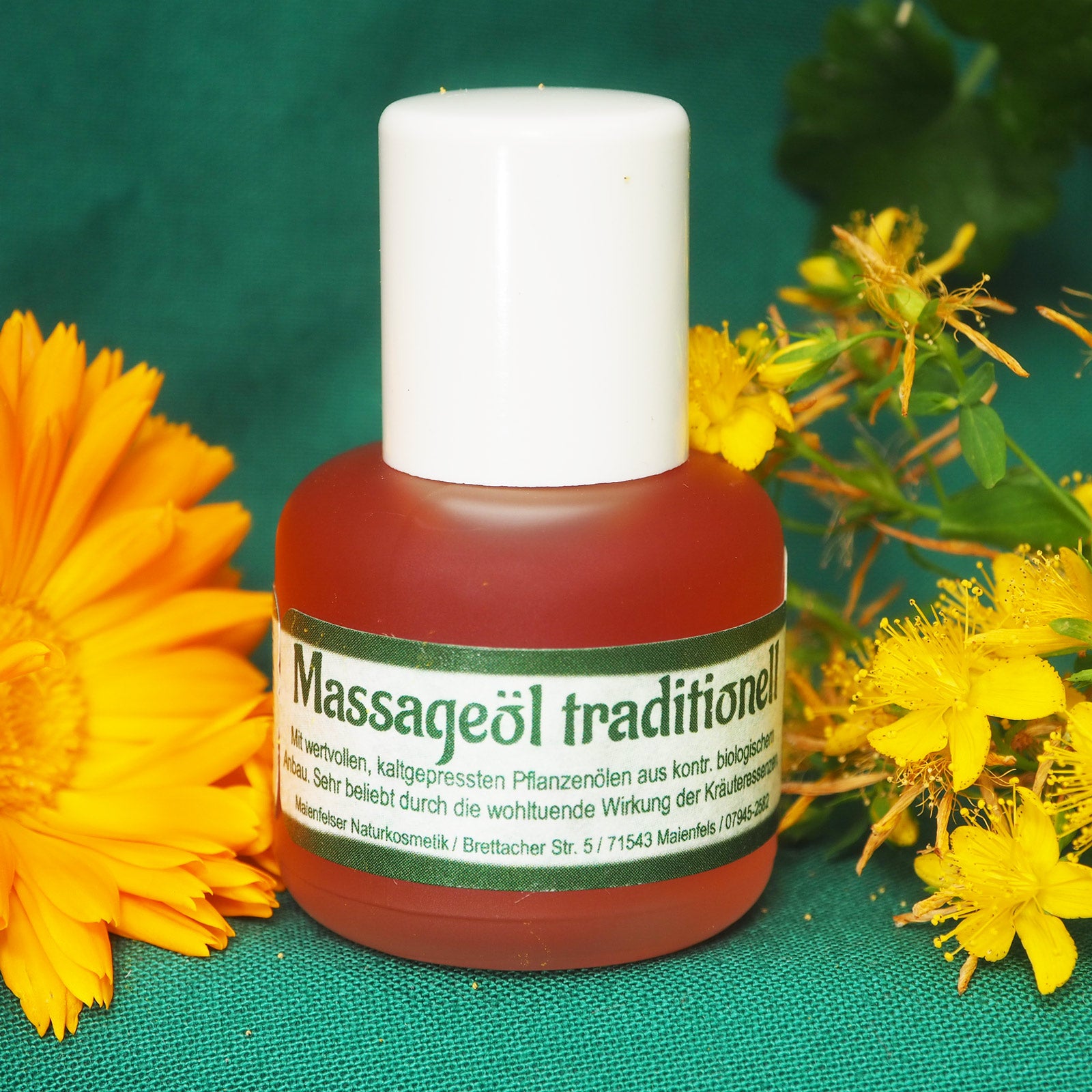 Massageöl tradition 15ml vor einem grünen Hintergrund dekoriert mit gelben Blüten